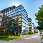 Modern glass office buildings with green surroundings.